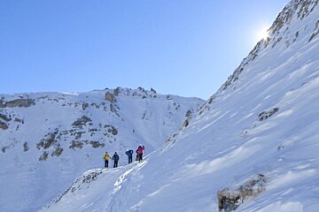 four skiers on a ledge