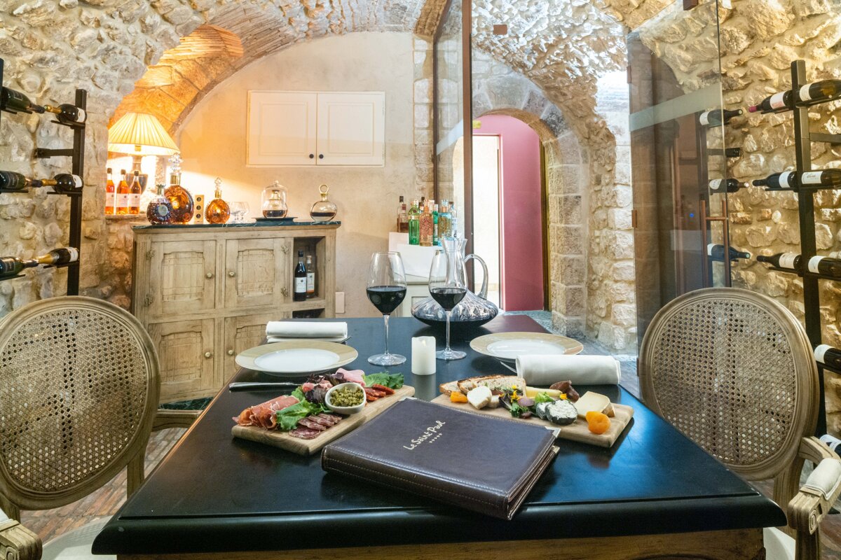 A table with plates and glasses of wine and a menu that says la cave paul