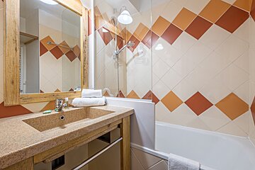 A bathroom with a sink a mirror and a bathtub