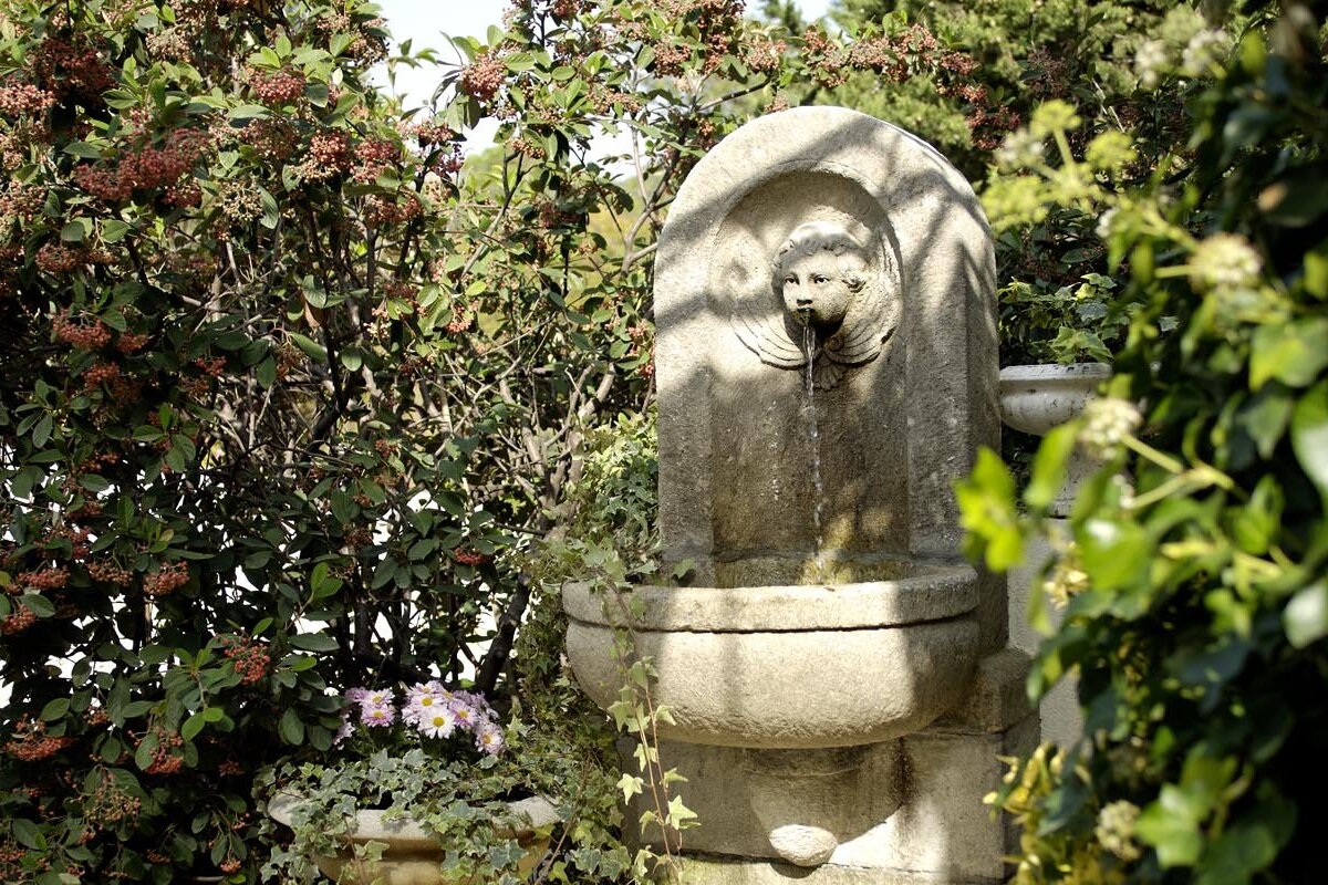 A stone fountain with a lion 's face on it