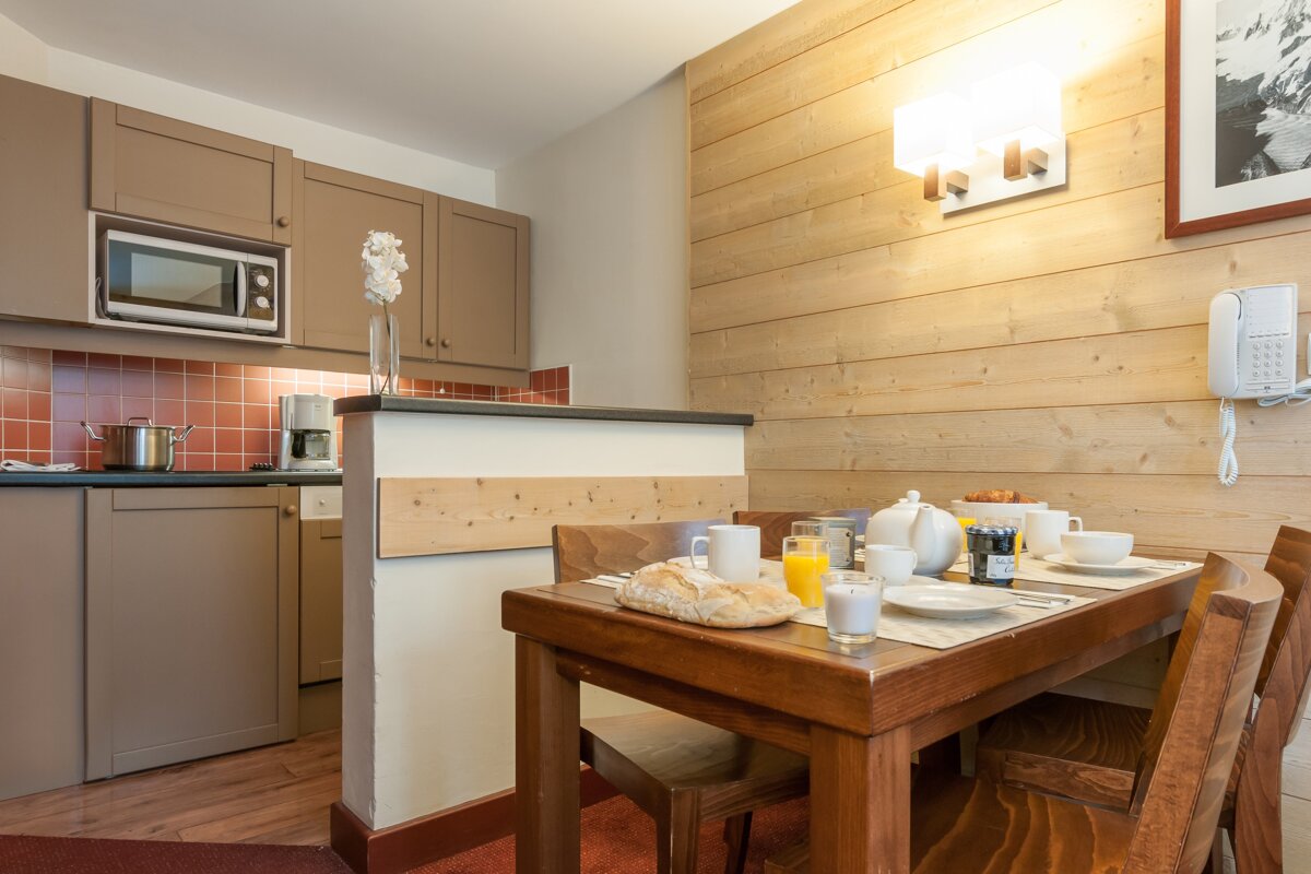 A kitchen with a table and chairs and a microwave