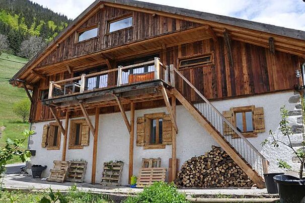 A large wooden house with stairs leading up to the second floor