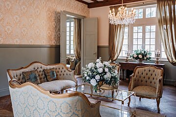 A living room with a couch and chairs and a chandelier