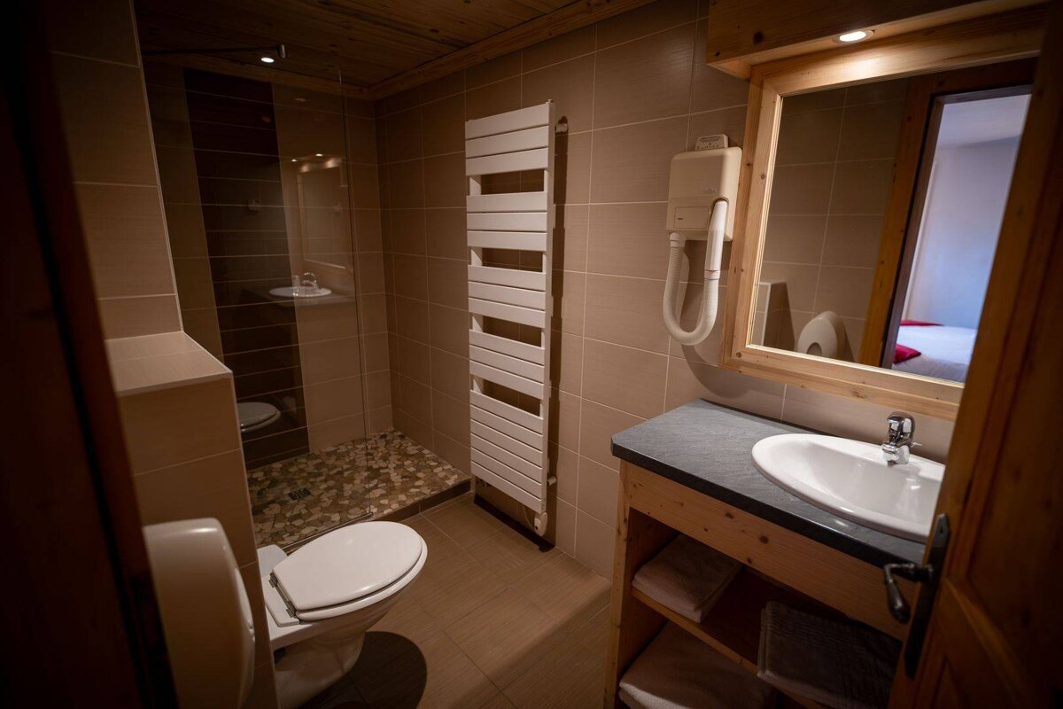 A bathroom with a toilet a sink and a towel rack