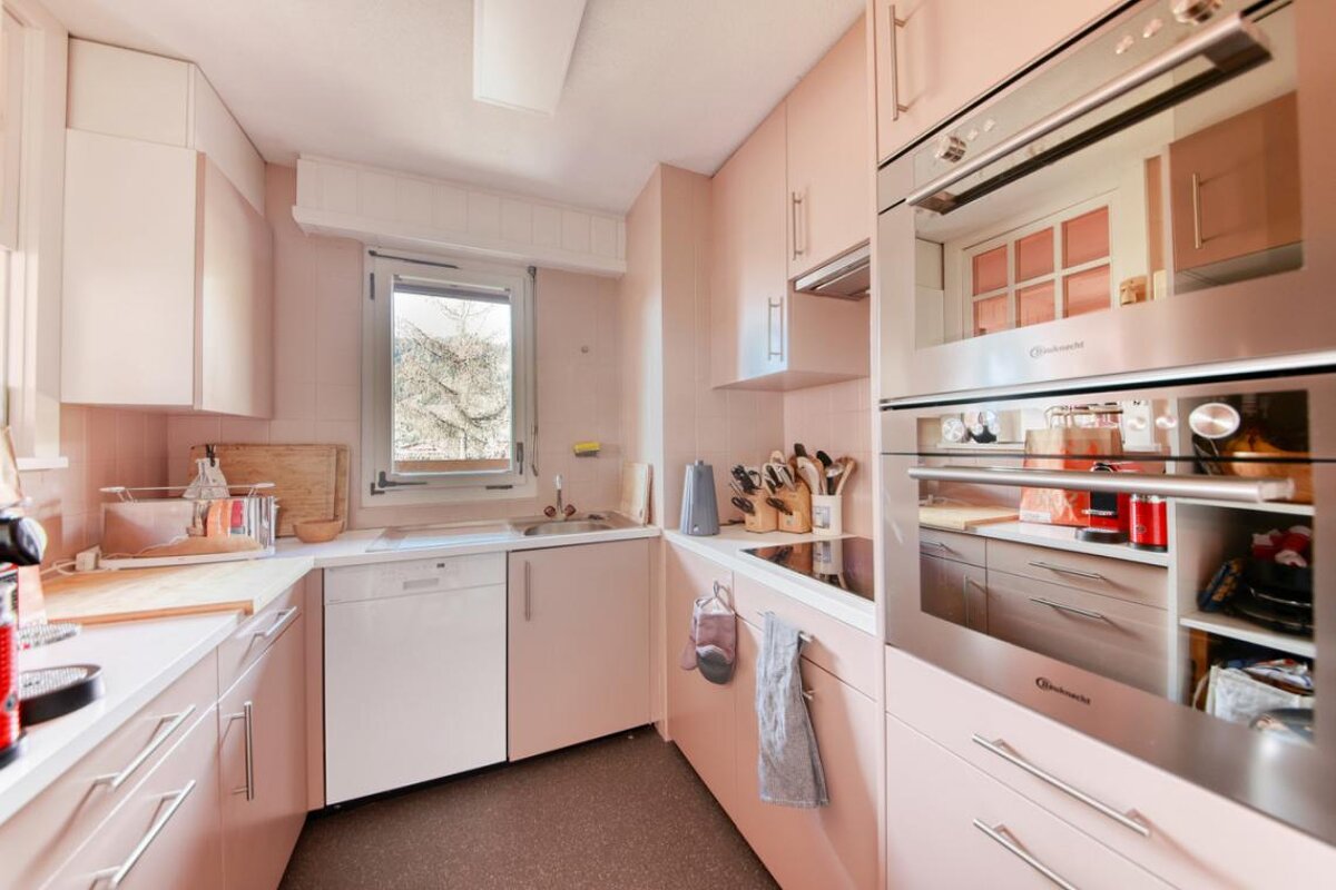 A kitchen with pink cabinets and a bauknecht oven