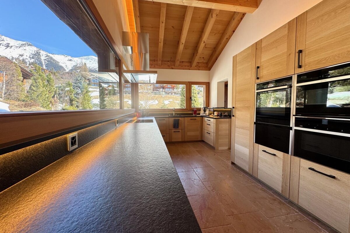 A kitchen with wooden cabinets and black counter tops