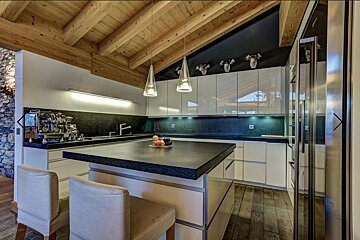 A kitchen with white cabinets and a black counter top