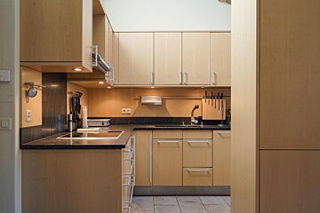 A kitchen with wooden cabinets and black counter tops