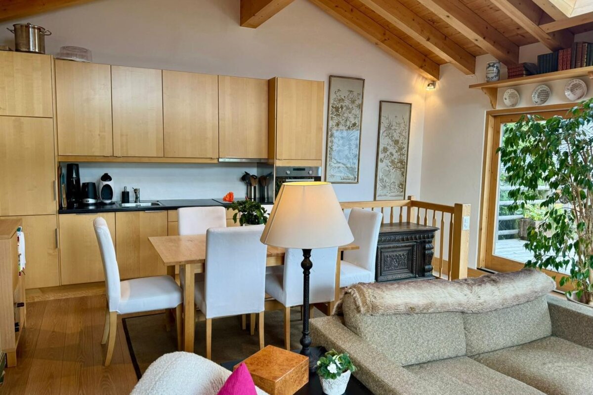 A living room with a table and chairs and a lamp