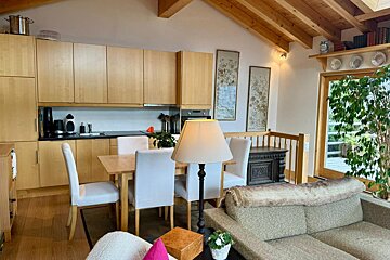 A living room with a table and chairs and a lamp