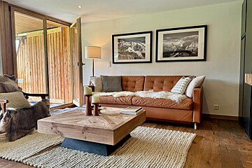 A living room with a brown leather couch and a wooden coffee table
