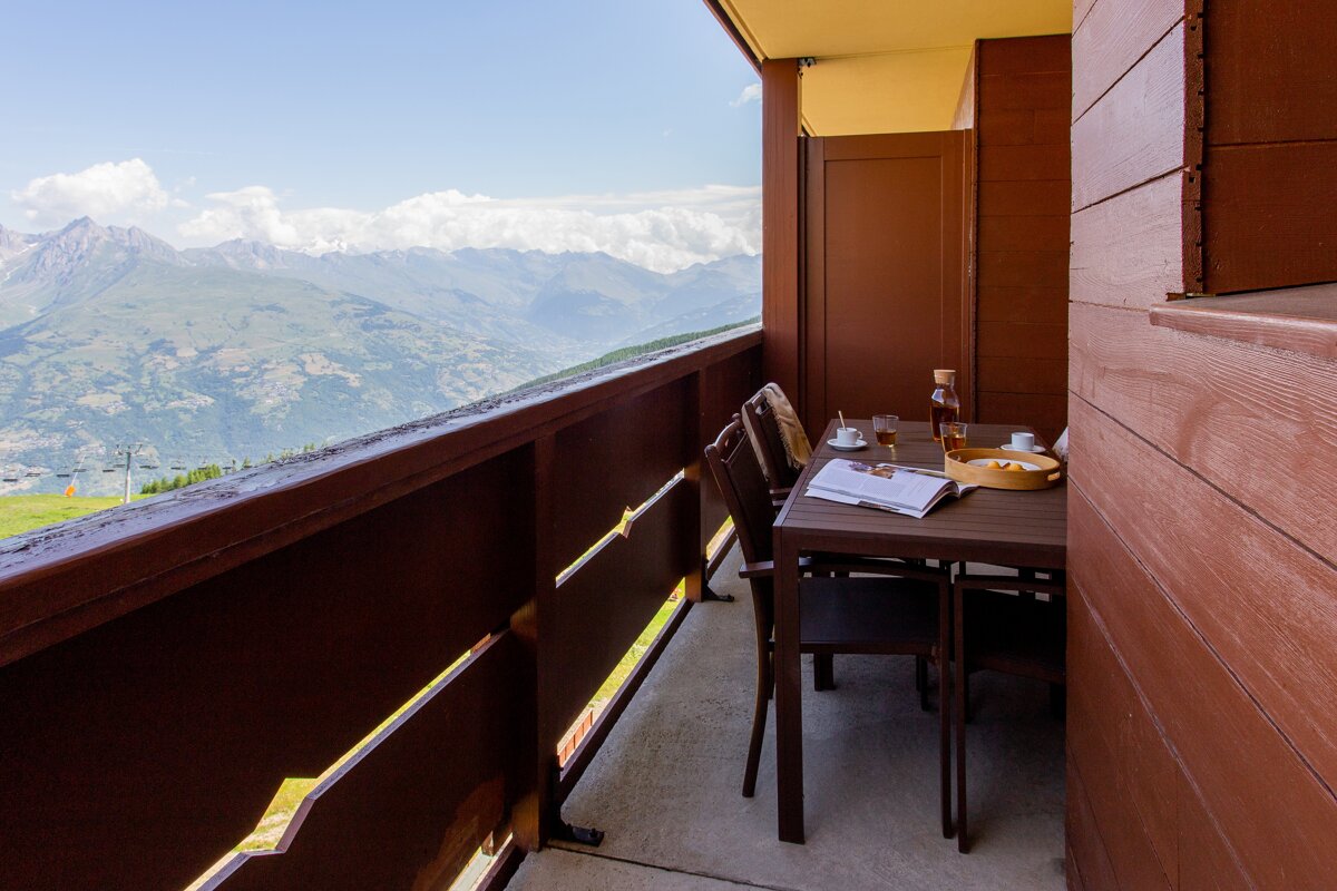 A balcony with a table and chairs and a book on it
