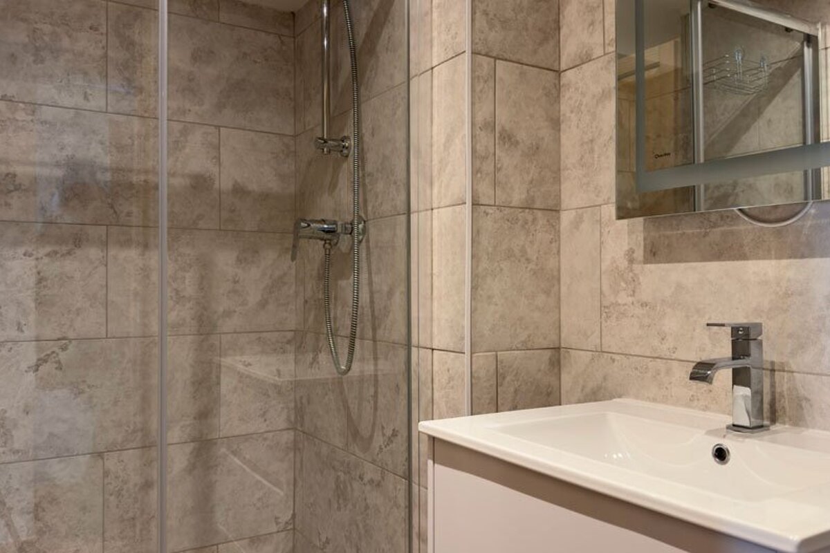 A bathroom with a sink and a walk in shower