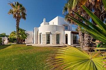 A white house with palm trees in front of it