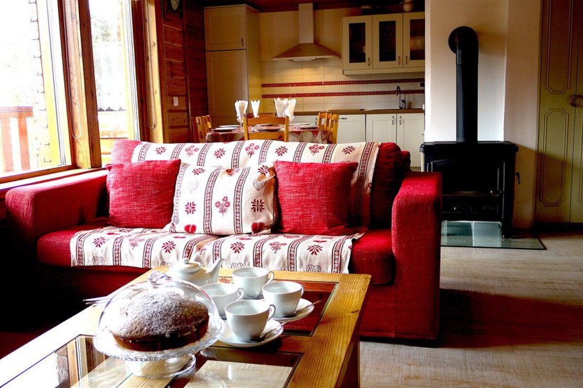 A living room with a red couch and white pillows