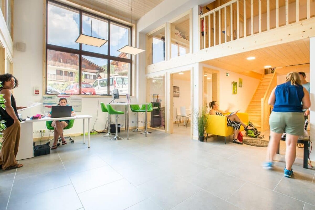 A woman sits at a desk with a laptop in front of her