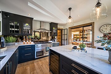 A kitchen with black cabinets and stainless steel appliances