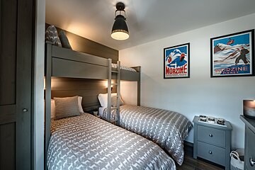 A bedroom with two bunk beds and a poster that says morzine