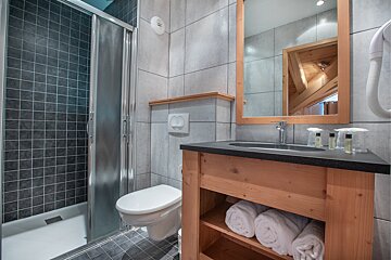 A bathroom with a toilet a sink and a mirror