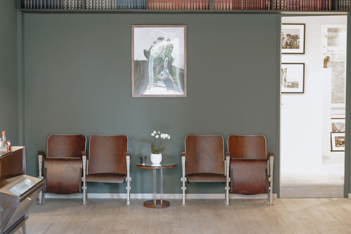 A row of chairs in a waiting room with a picture on the wall above them