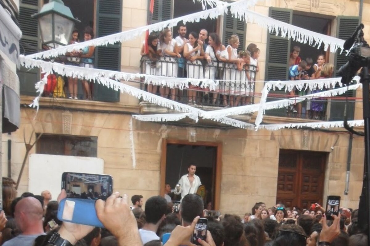 lots of people wearing white on balconies watching the festival