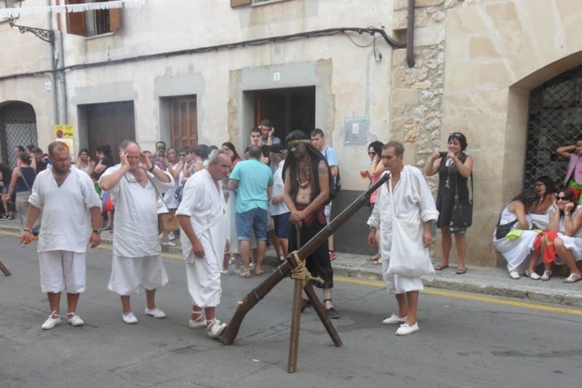 A group of men in white clothes with a gun in the street