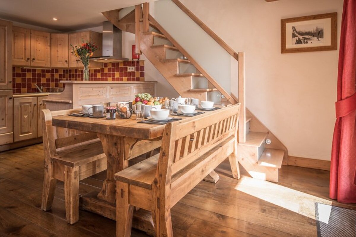 A wooden table with a bench underneath it in a kitchen