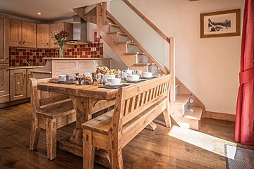 A wooden table with a bench underneath it in a kitchen