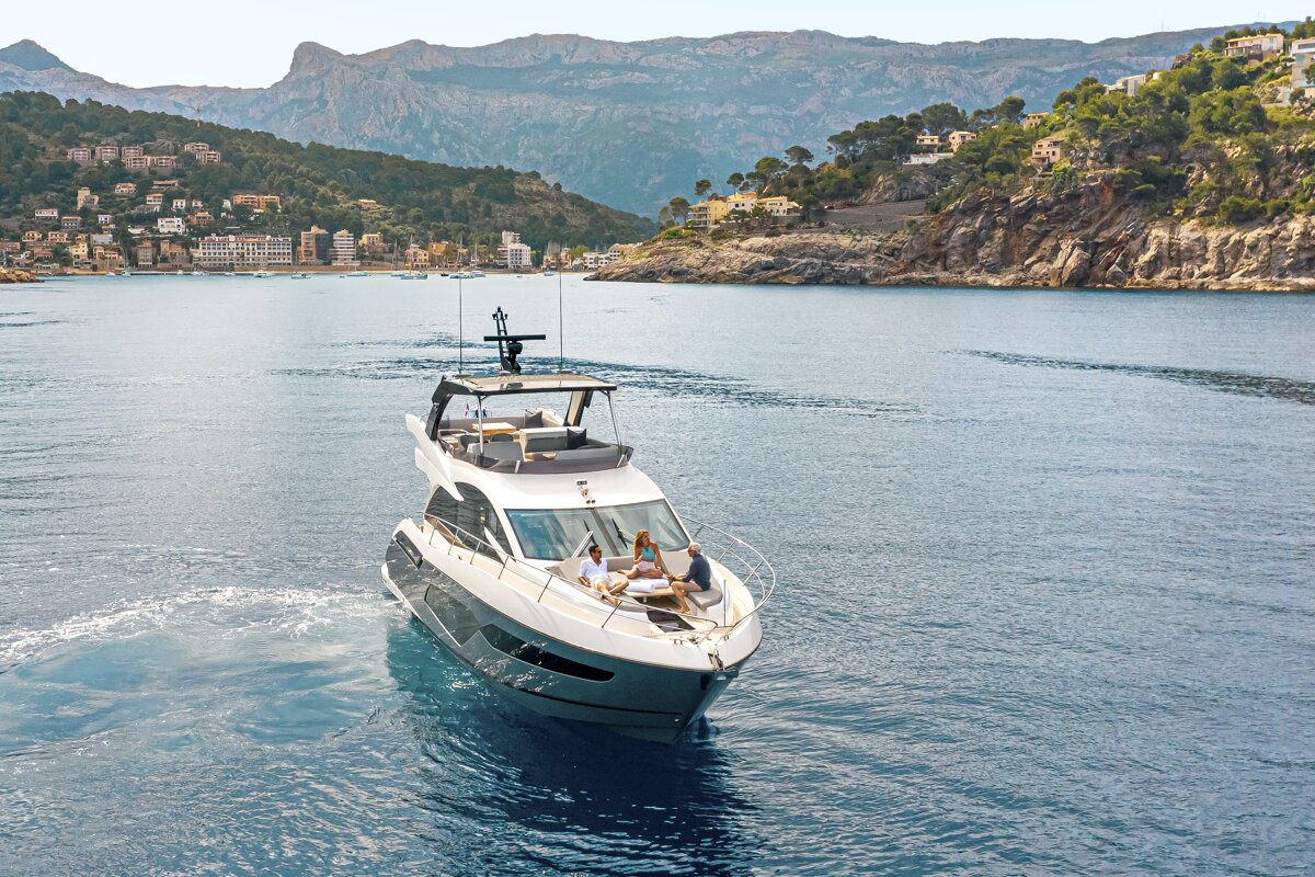 A boat is floating on a body of water with mountains in the background