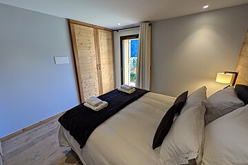 A bedroom with a large bed and a window