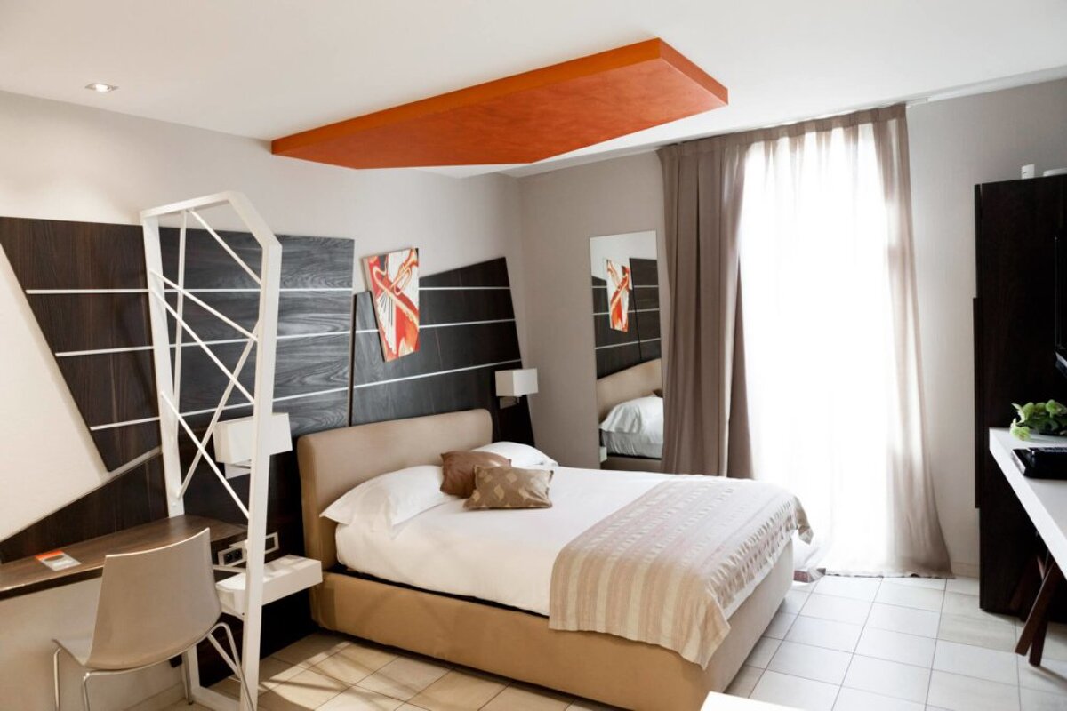 A hotel room with a bed and a desk