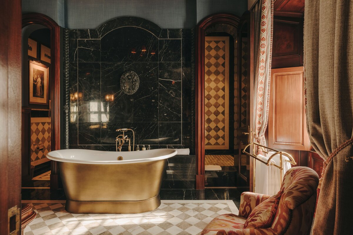 A bathtub in a bathroom with a chair in front of it