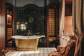 A bathtub in a bathroom with a chair in front of it