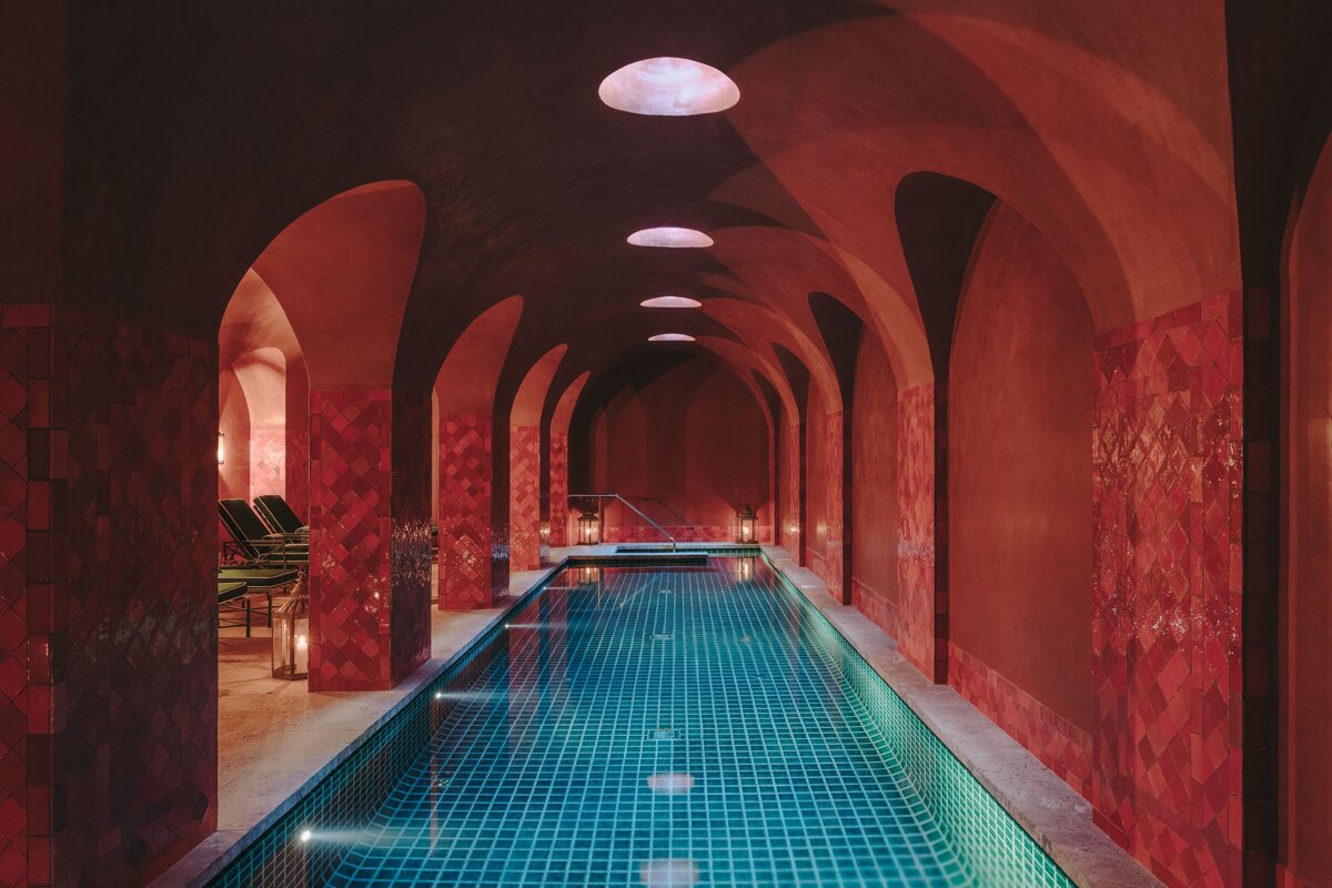 A swimming pool in a dark room with red walls