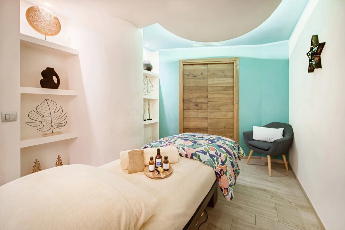 A massage table with a tray of essential oils on it