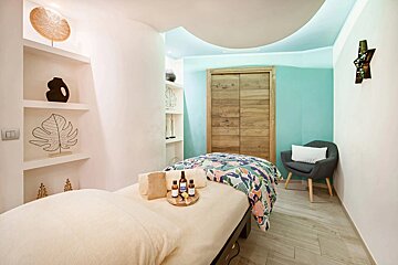 A massage table with a tray of essential oils on it