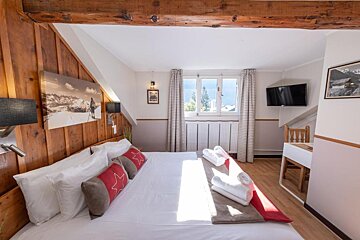 A hotel room with a large bed and a window