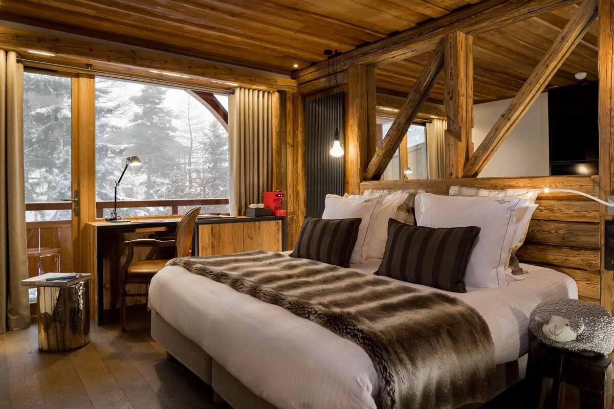 A bedroom with a large bed and a desk