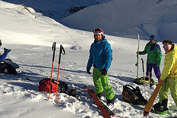 A group of skiers are standing in the snow