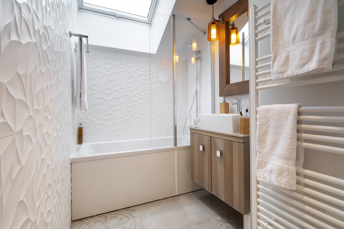 A bathroom with a skylight above the bathtub