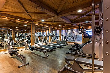 A gym with a wooden ceiling and lots of equipment