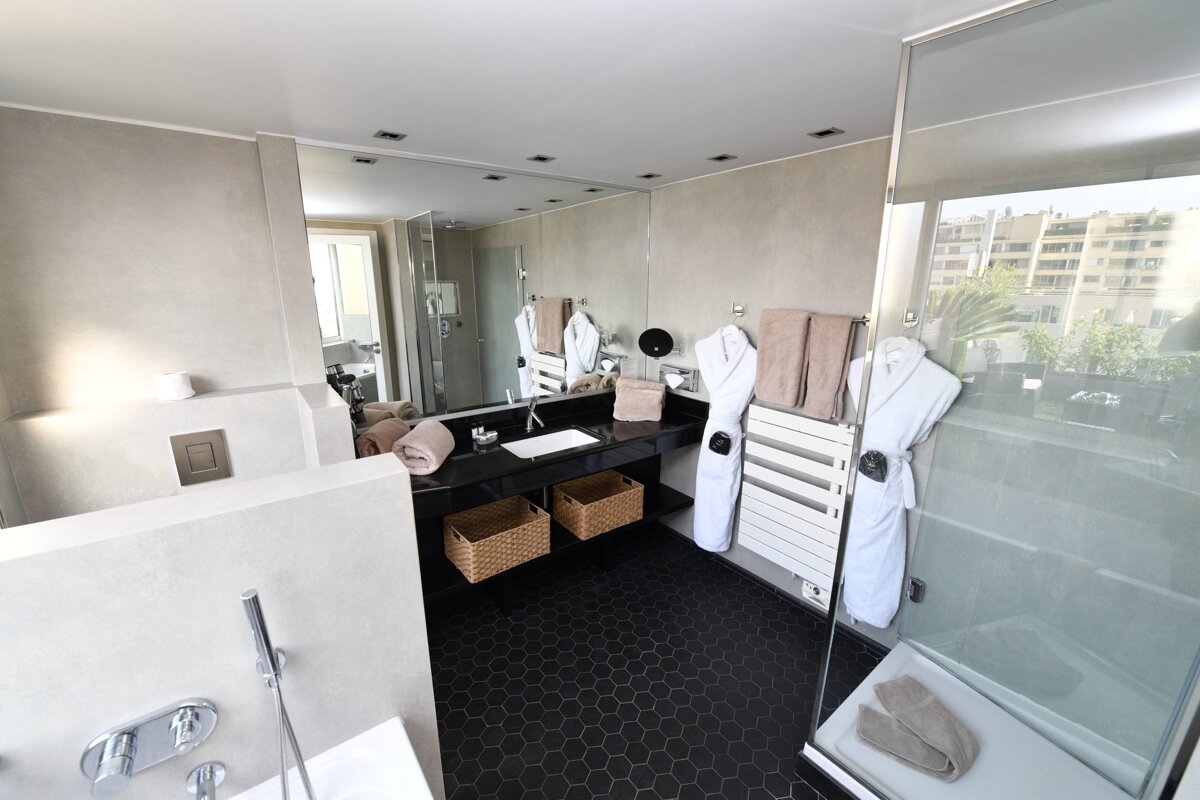 A bathroom with a large mirror and a white towel rack