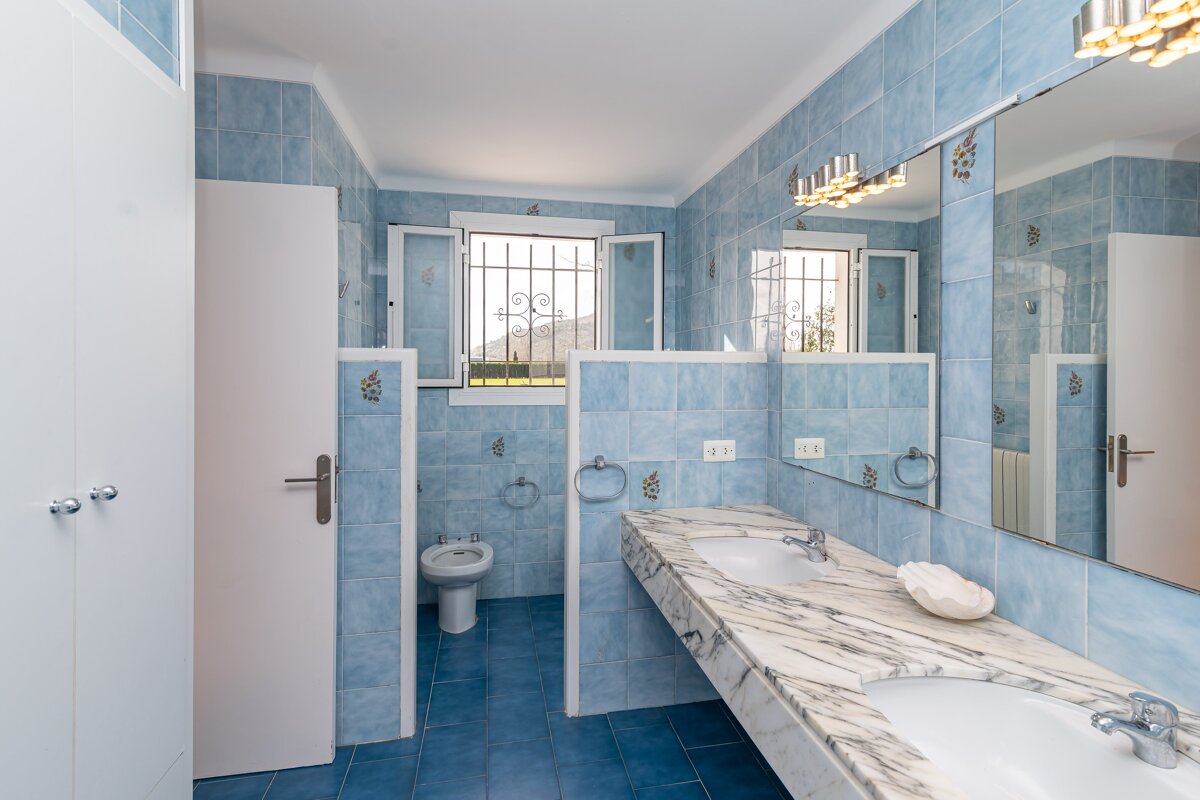 A bathroom with blue tiles and a sink