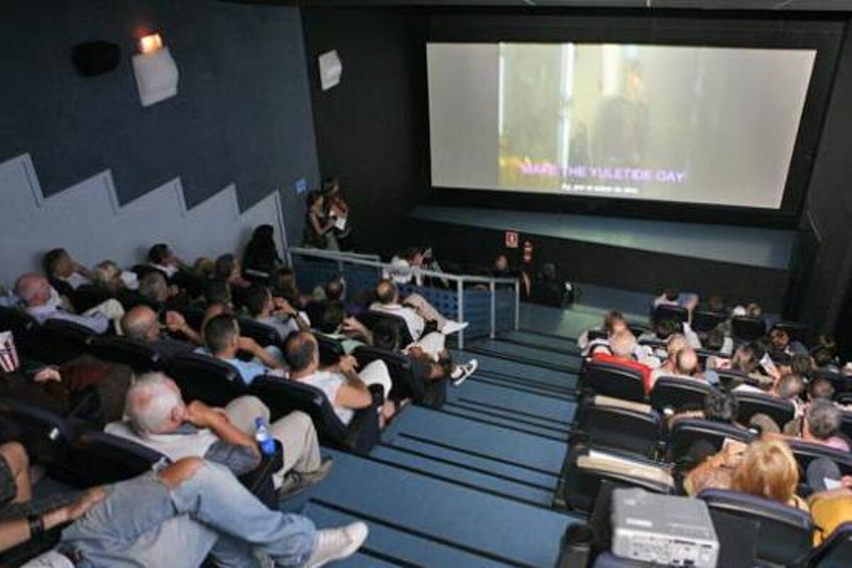 A large group of people are watching a movie in a theater
