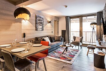 A living room with a couch a table and chairs