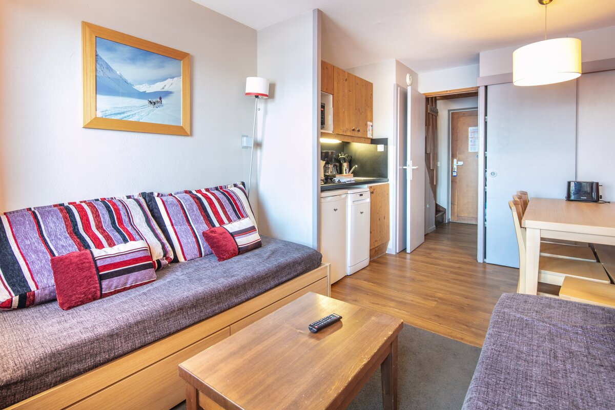 A living room with a couch a table and a picture on the wall