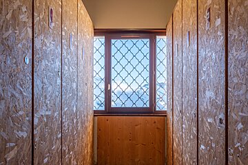 A row of wooden lockers with a window in the middle
