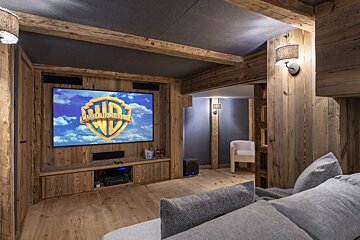 A projector screen shows a movie from warner bros