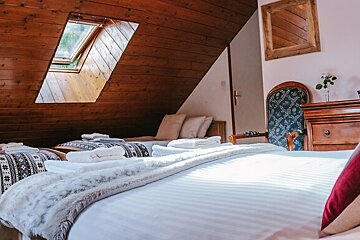A bedroom with two beds and a skylight on the ceiling
