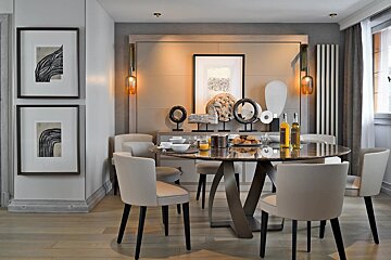 A dining room with a round table and chairs